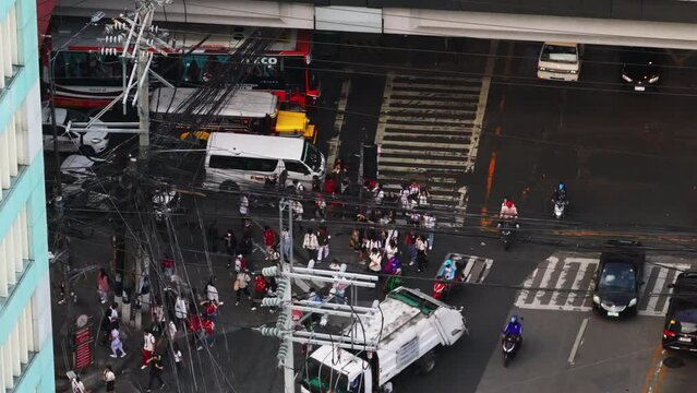 Lively city scene at a bustling Manila intersection, where people, cars, and pedestrians come together in a vibrant urban setting