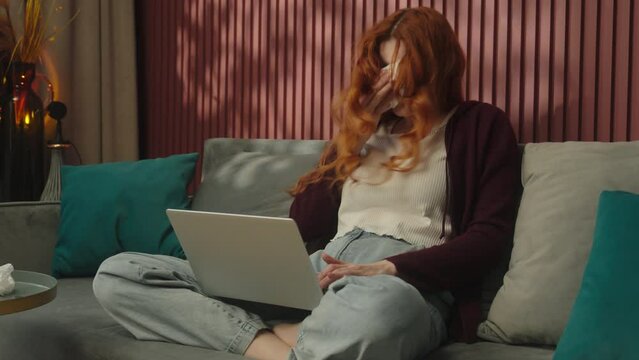 Sick ill Caucasian woman girl female freelancer student health problem influenza flu sickness viral infection allergy sneeze suffer rainy nose blow in napkin sneezing working online laptop home covid