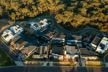 Last light aerial view of newly constructed modern Australian homes with Eucalyptus trees in the background.