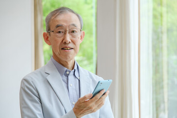 スマートフォンを使う高齢者の男性
