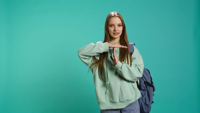 Portrait of assertive woman asking for timeout, doing hand gestures, feeling fatigued. Unhappy girl doing vehement pause sign gesturing, wishing for break, studio background, camera B