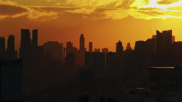 Breathtaking asian city skyline at sunset, with highrise buildings against a warm, golden sky. Urban, cityscape, and architecture concepts