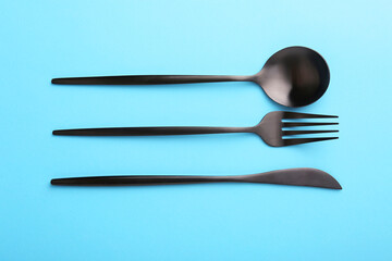 Stylish cutlery set on light blue table, flat lay