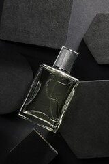 Stylish presentation of luxury men`s perfume in bottle on black background, top view