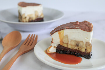 Homemade Banoffee cake made from bananas, whipped cream and a thick caramel sauce on table.