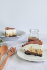 Homemade Banoffee cake made from bananas, whipped cream and a thick caramel sauce on table.