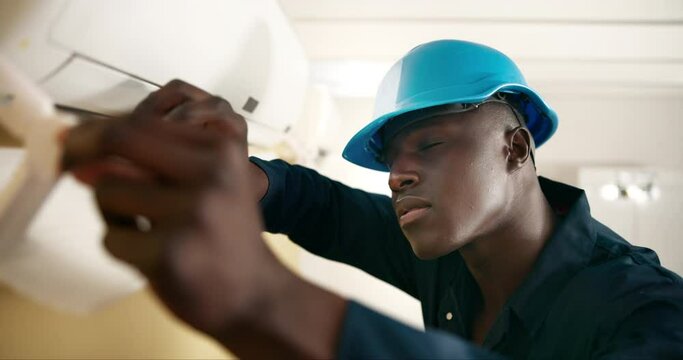 Air conditioning, repair and black man with maintenance and electrician with aircon cleaning and job. Working, technician and construction worker with thermostat check and contractor in a home