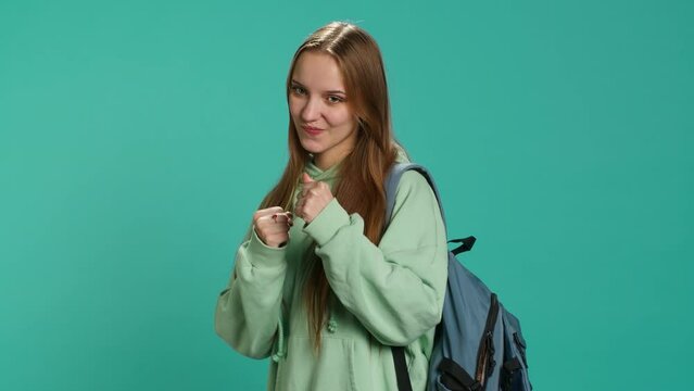 Woman doing fighting stance, pretending to do boxing, isolated over studio background. Young fighter throwing punches, doing athletic guard pose during combat practice, camera A