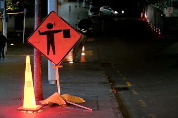 a stop on request sign next to a glowing traffic cone on a street