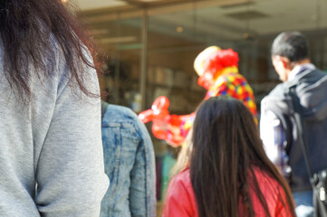 Obraz premium 町中で芸を披露している大道芸人を囲うようにしてできた人だかり