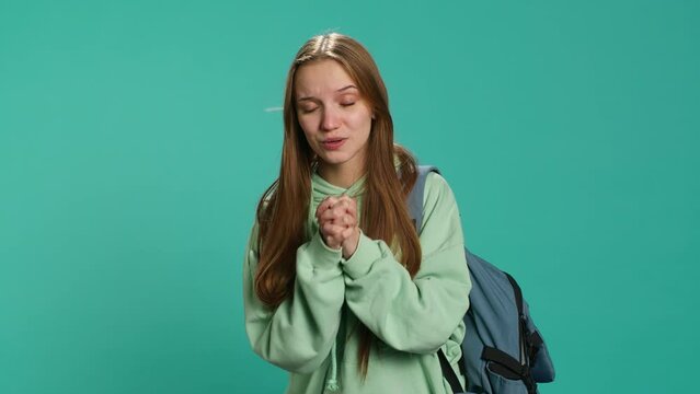 Woman doing begging hand gesture, in ardent need of favor from friend, isolated over studio background. Young girl doing please gesturing, requesting assistance, camera A