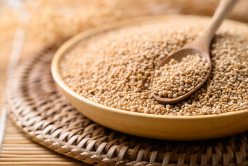 Brown quinoa seed in wooden bowl with spoon, Healthy food ingredient