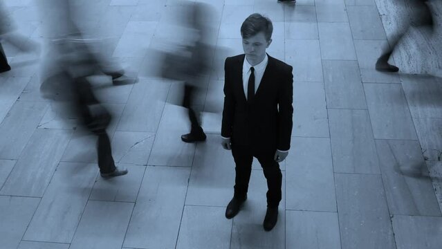 Young Businessman Surrounded By Pedestrians Commuting in the City Streets