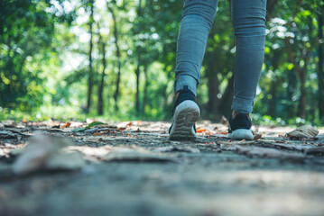 sneaker shoes young woman traveler sit down on summer park. Focus on sneaker shoes and jeans on...