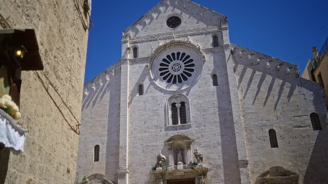 The image captures the stunning facade of bari cathedral in puglia, italy on a clear day, showcasing its impressive architecture, windows, and sculptures.