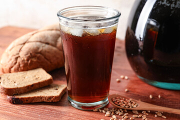 Glass of tasty kvass on table