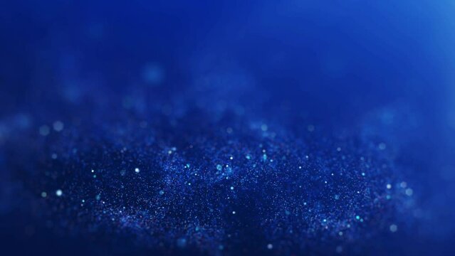 Abstract blurred sparkling or glittering particles on dark blue background.