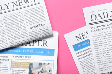 Different newspapers on pink background