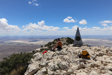 Hiker resting at summit of Guadalupe Peak, Guadalupe Mountains National Park, Texas