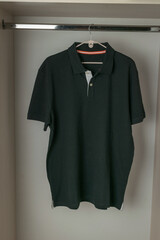 Black Polo Shirt Hanging on a Hanger in a Wardrobe