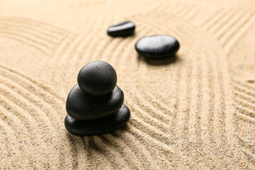 Black spa stones on sand. Zen concept