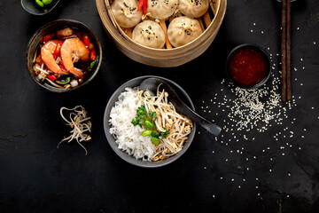 Chinese hot food. Dumplings, soy sauce, shrimp on black background. Traditional asian lunch