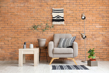 Interior of living room with grey armchair, lamp and table