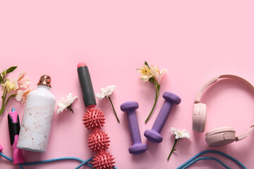 Composition with sports equipment, headphones and beautiful flowers on pink background