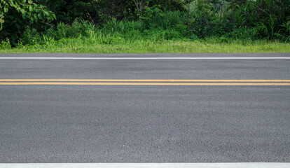Side view of asphalt road with forest