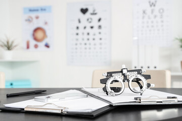 Trial frame with clipboards on table at oculist's office, closeup