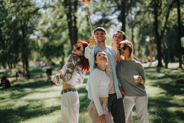 A group of happy, overjoyed friends enjoys their free time in a sunny park, capturing moments with...