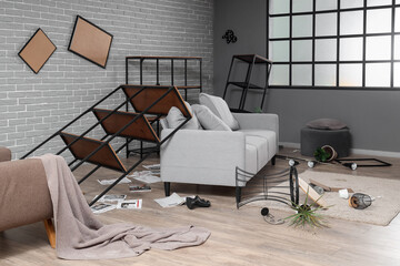Interior of messy living room with sofa and shelf units