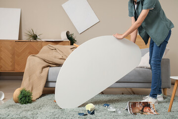 Woman taking overturned table after earthquake at home