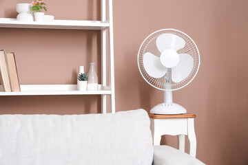 Modern electric fan on small table in living room