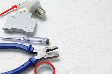 Electrician's tools on white grunge background, closeup