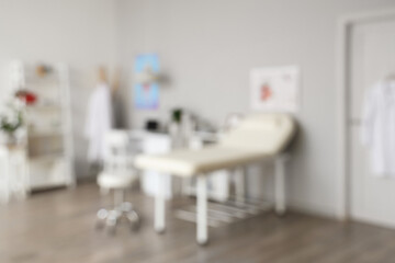 Blurred view of medical office with couch and doctor's workplace