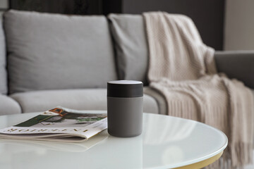 Air humidifier with magazine on table in living room, closeup