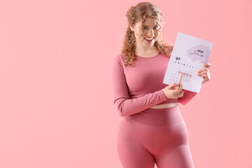 Female trainer with menstrual calendar on pink background