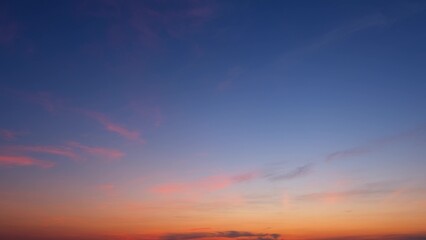 A serene sunrise with a gradient sky transitioning from deep blue at the top to warm orange near...