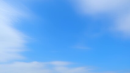 A clear blue sky with soft, white clouds dispersed across it. The contrast between the deep blue...