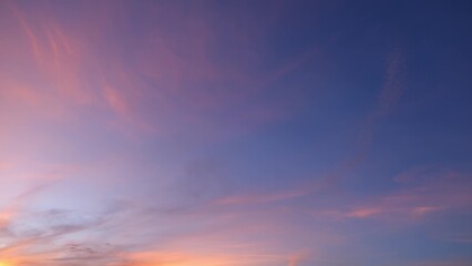A peaceful sunset with the sky painted in soft shades of pink, purple, and blue. Wispy clouds...
