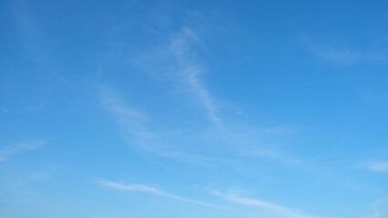 A clear blue sky with a few wispy white clouds scattered across it. The overall effect is tranquil...