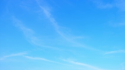 A bright blue sky with a few faint, wispy clouds. The simplicity and clarity of the sky create a...