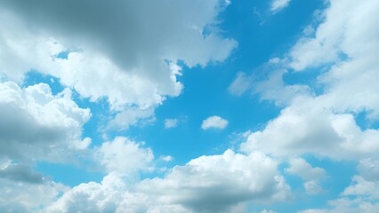 A vibrant blue sky adorned with an array of white and grey clouds. The clouds vary in density and...