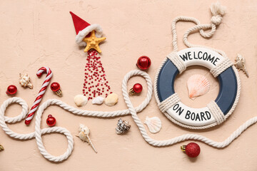 Decor lifebuoy ring, rope, shells and starfish with Christmas decor on beige background. Top view