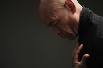 praying to god with hands together on dark background stock photo	