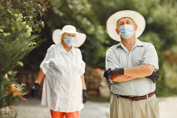 Beautiful old couple spend time in a summer garden