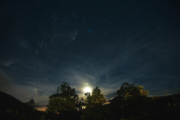 Fototapeta premium The Moon and Countless Stars in the Night Sky over the Mountains of Rio de Janeiro State, Brazil
