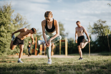 Group of people stretching and exercising in the park, enjoying a healthy outdoor workout routine...