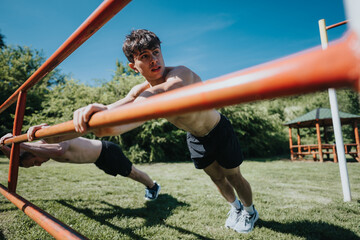 Two men doing outdoor workouts in an urban park, using metal bars for calisthenics against a clear blue sky. - Powered by Adobe
